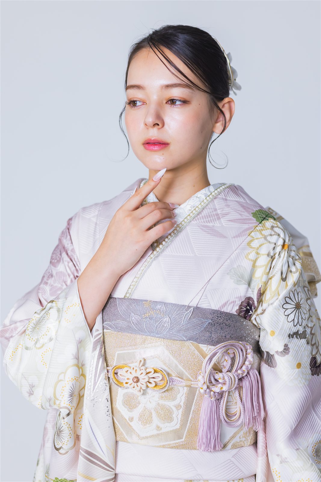 淡いピンクに菊の柄が入った振袖を着た上半身