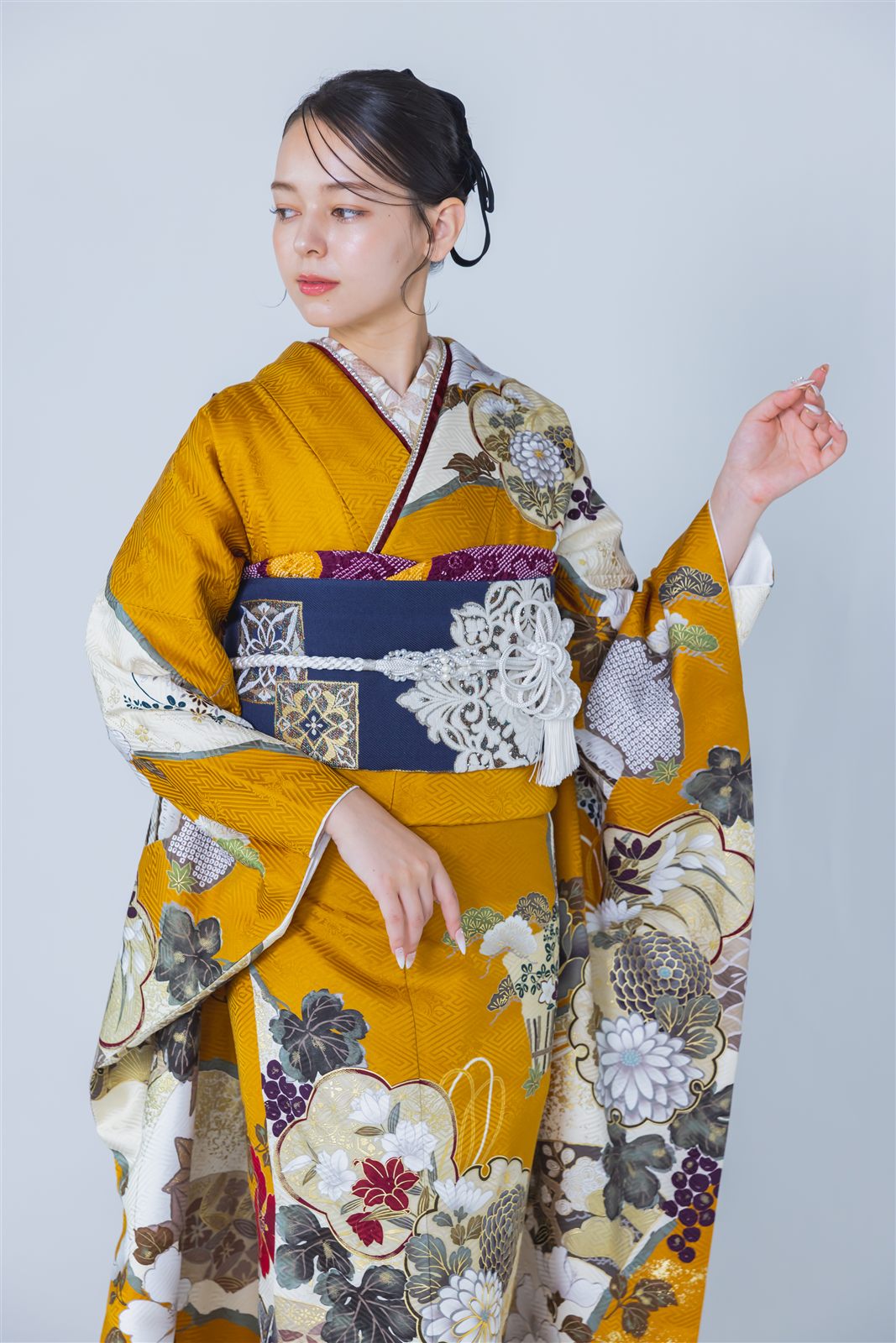 からし色の振袖に紺の袋帯、白の帯締め、絞りの帯揚げを合わせたコーディネート