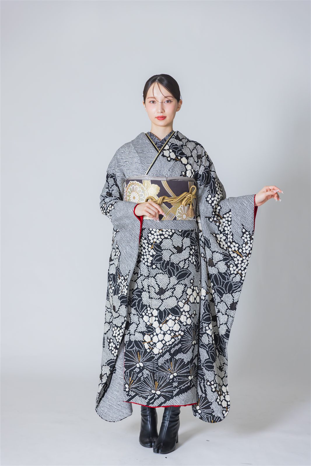 白と黒の総絞りで花模様を表した振袖に、黒地に金の菊の袋帯を合わせた全身